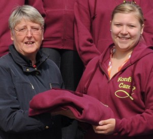 Der Förderkeis-Mitglied Ilse Pohl-Ringkamp übergibt Teamer-Jacken für das Konfi-Camp